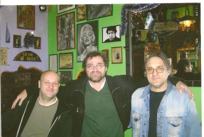På Cinema Pub i Bela Crkva. Miroslav, jag och Miroslavs kompis. Miroslavs kompis och jag älskar Dylan. Den magiske mästaren håller ett vakande öga över oss från sin plats på väggen.
